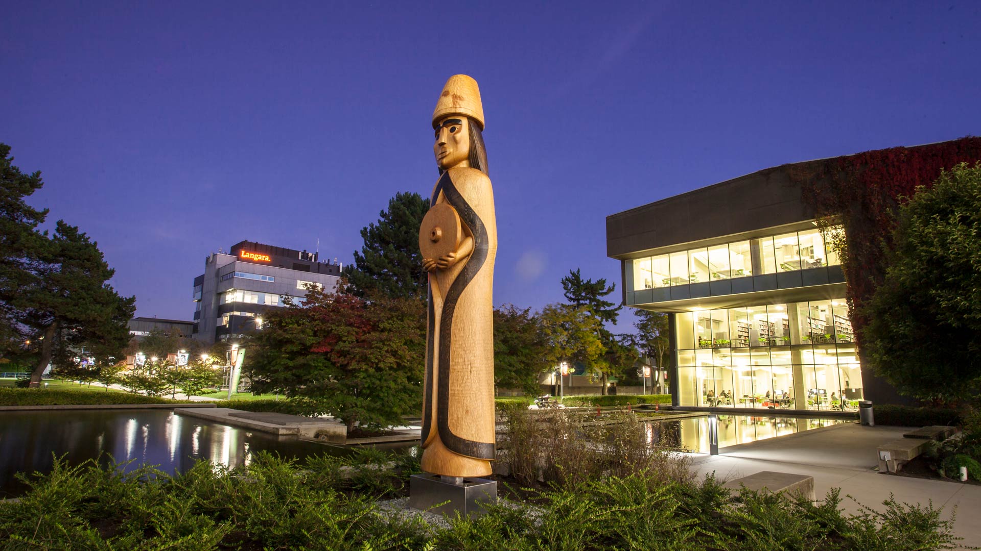 The Musqueam House Post near the Langara Pond at night.