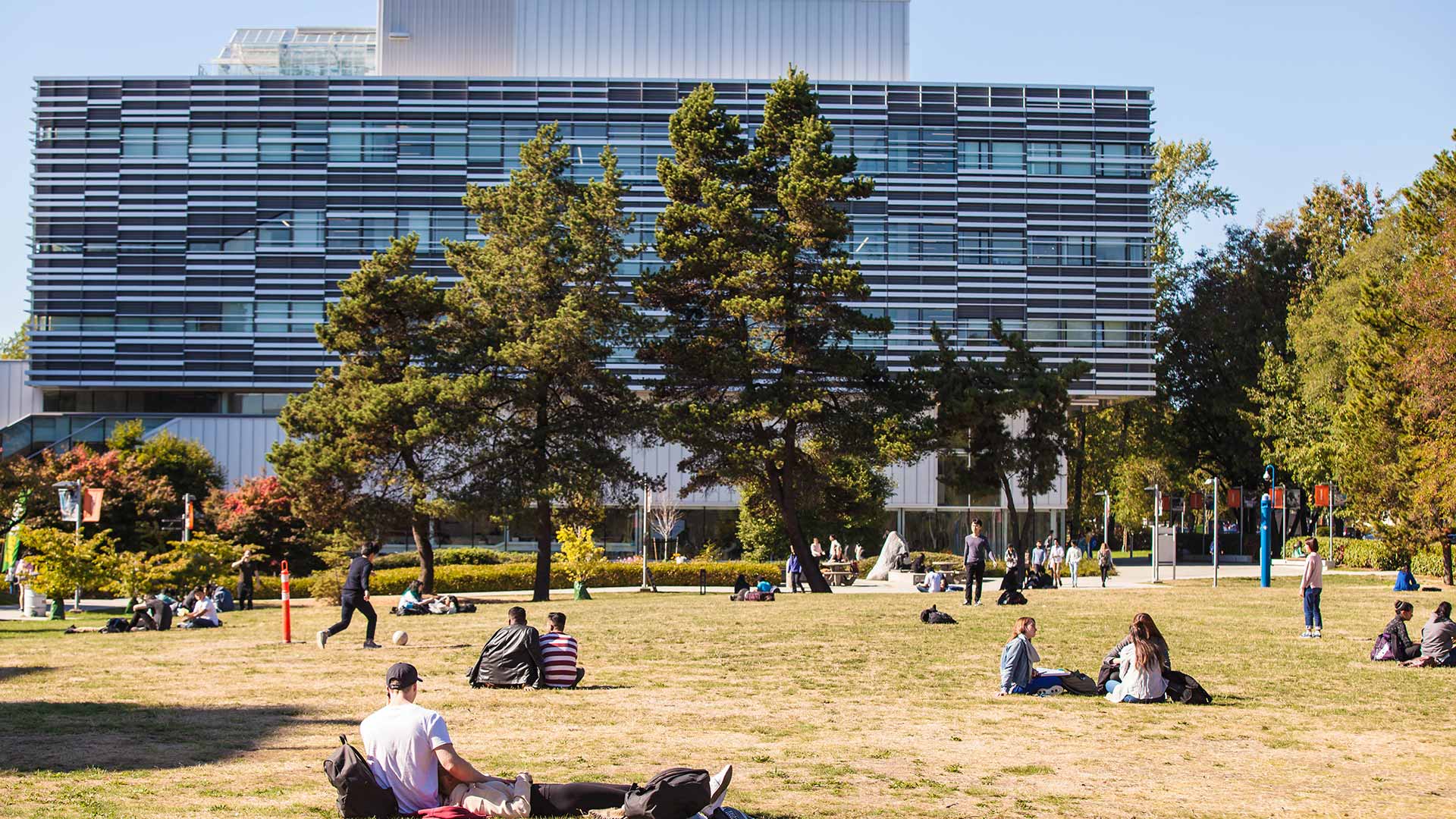 Students are lying on the front lawn, enjoying a break from classes.