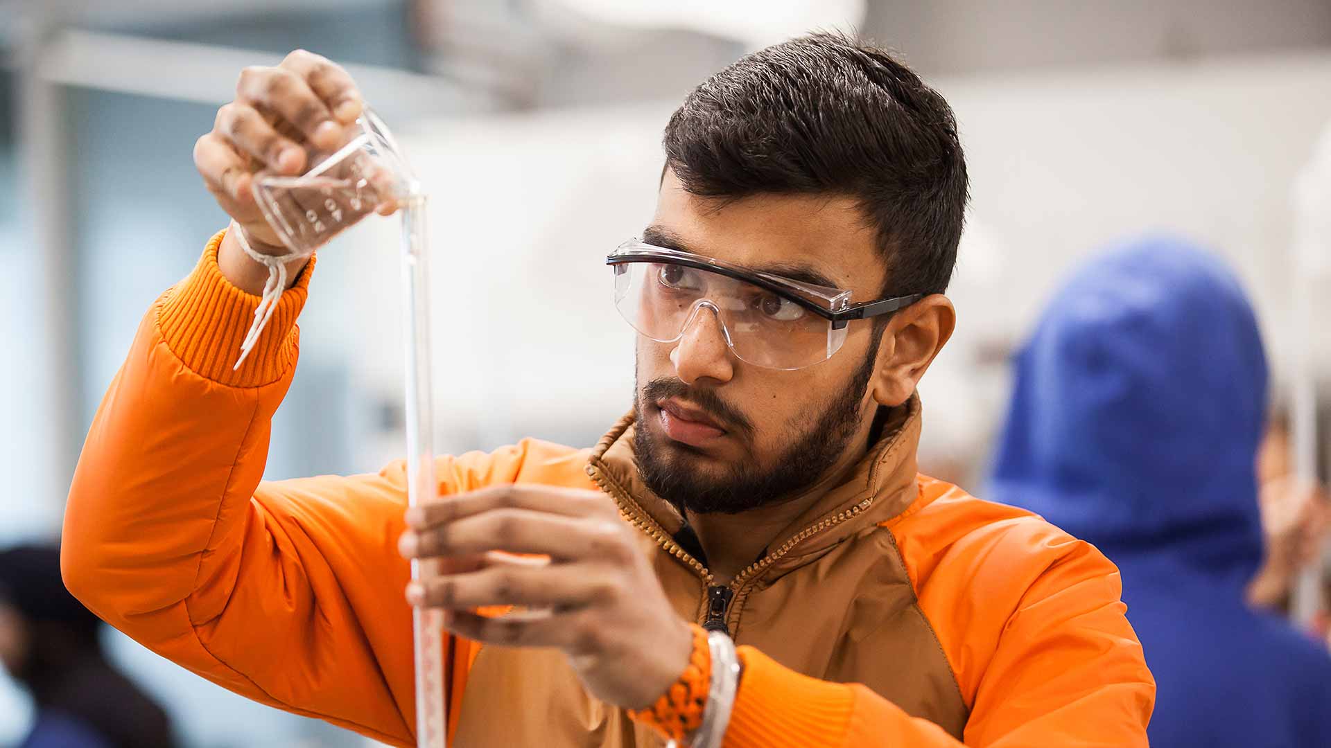 A student dives into a world of discovery, conducting chemical experiments in the vibrant atmosphere of the T Building.