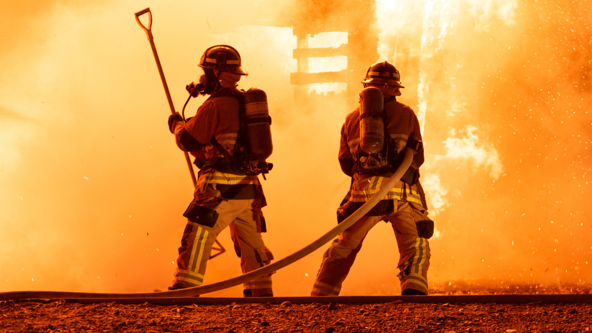 Two firefightings battling a building fire.