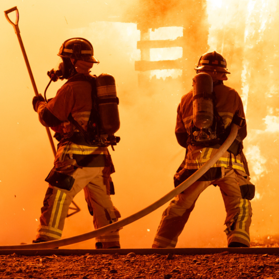 Two firefightings battling a building fire.