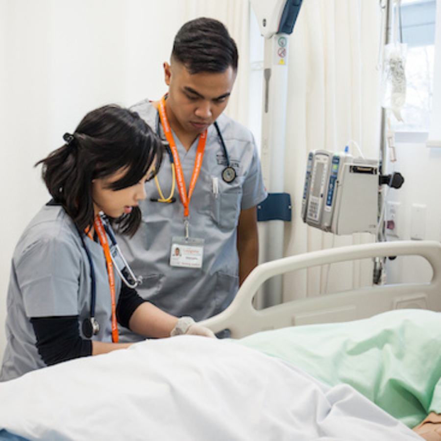 Nursing students working on a medical mannequin in the simulation lab.