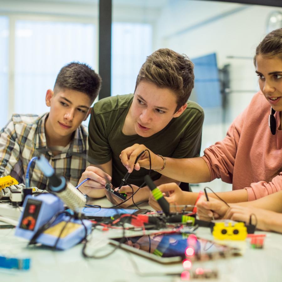 Five teens work on circuitboards to learn how they work during a summer camp session at Langara.
