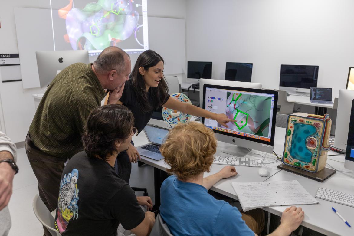 An instructor shows students how to read DNA on a computer screen.
