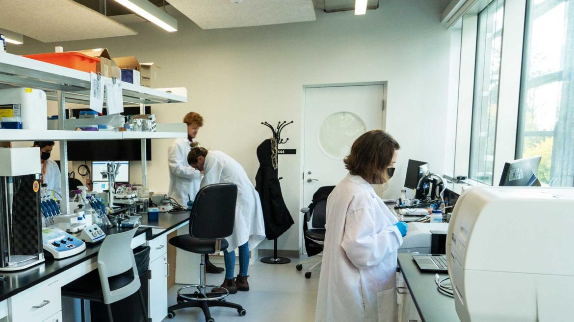 A group of Bioinformatics students learning through laboratory work in class.