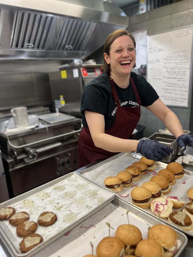 Adriana Purdie laughing while serving burgers.