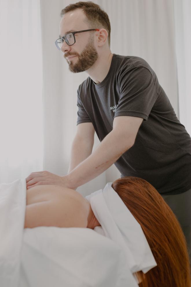 Anton Lobashkov massaging a patient who is face down.