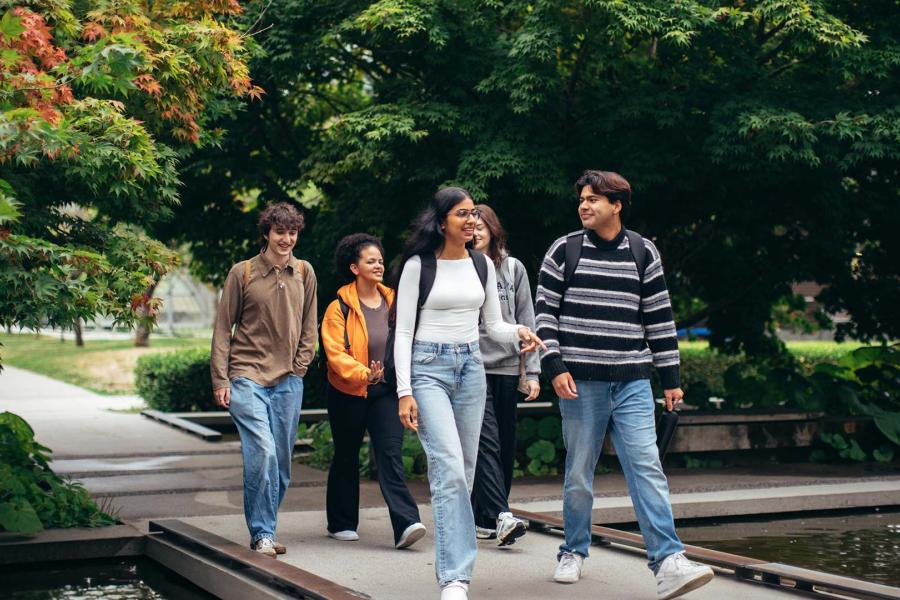 Students are walking to their next class, passing by the pond.